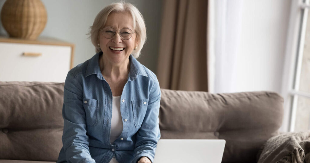 Older woman on computer Money Matters: 5 Tips for Paying for a Move to a Senior Living Community